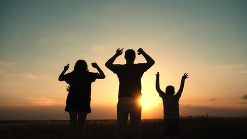 Family Silhouette Celebrating Sunset in Rural Field
