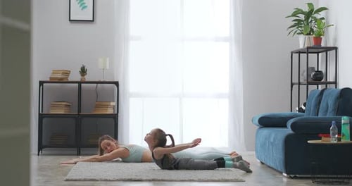 Woman and Girl Exercising Together at Home