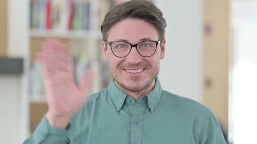 Mann mittleren Alters winkt in die Kamera