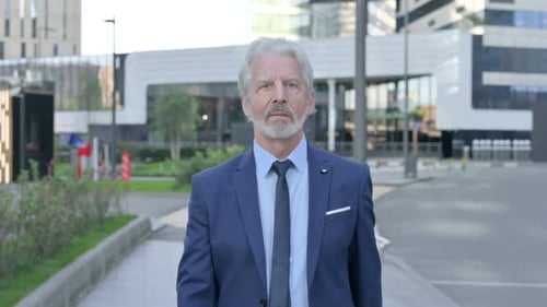Senior Businessman Walking with Determination in City Setting