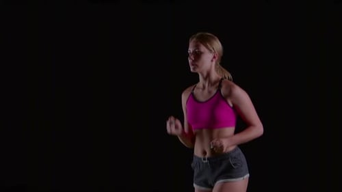 Athlet in Sportkleidung läuft leicht auf einem schwarzen Bildschirm. Zeitlupe. Nahaufnahme
