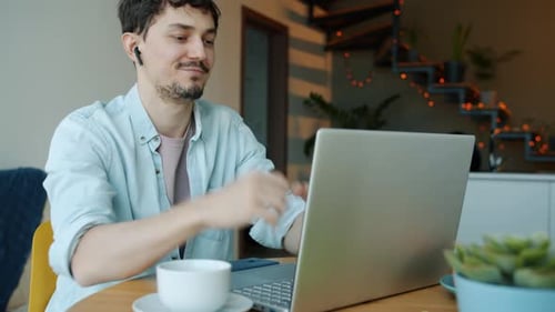 Young Man Video Conferencing on Laptop at Home