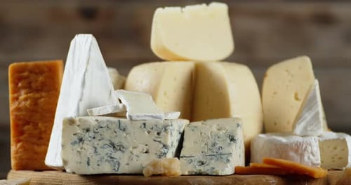 Assortment of Gourmet Cheeses on a Wooden Board