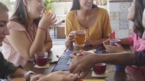 Friends Share Food and Drinks at Cafe Table