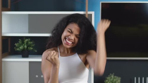 Woman Celebrating Good News Indoors with Cheerful Expression