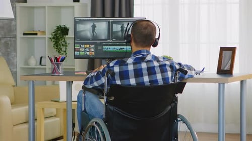 Man Editing Video at Desk in Wheelchair