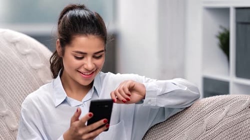 Smiling Woman Using Cellphone Indoors