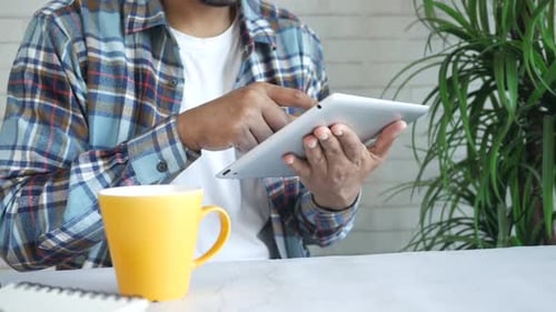 Young Man Working on Digital Tablet at Office Desk