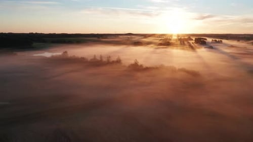 Golden Sunrise Over Misty Rural Landscape