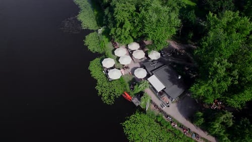Drone Aerial Footage of the Umbrellas of a Small Cafe on the Lake Shore