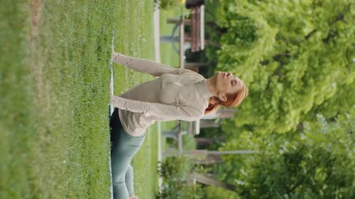 Woman Practicing Yoga in an Urban Park on Grass