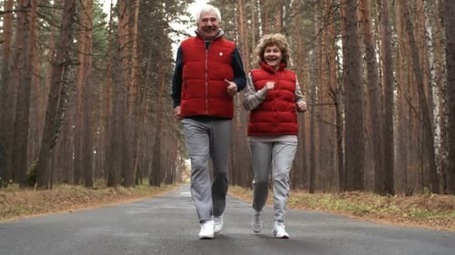 Aged Couple Running in Forest