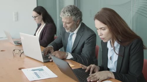 Business Professionals Working Together on Laptops in Office