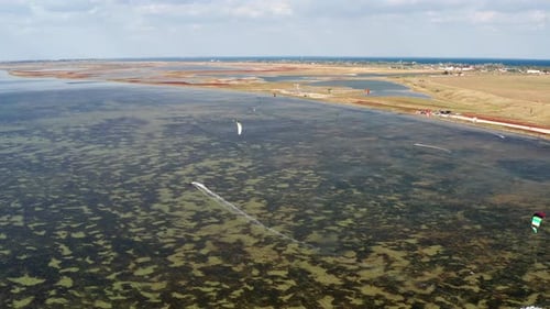 People go kitesurfing on the sea. The wind carries the athlete along the sea waves.