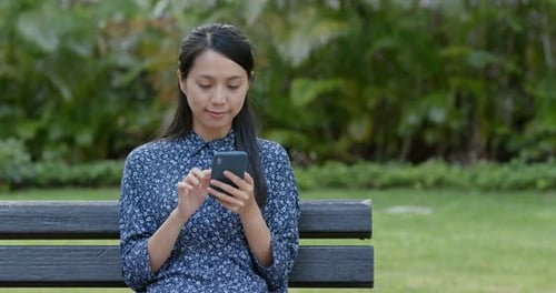 Woman use of mobile phone in park