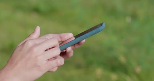 Frau benutzt Handy über Sonnenlicht
