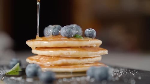 Sirup wird auf Pfannkuchen gelegt