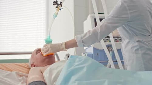 Caregiver Attends to Patient in Hospital Bed