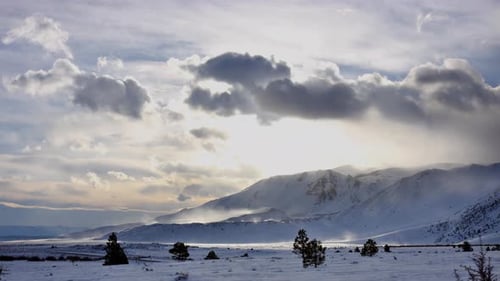 Winter Mountain Range with Dramatic Clouds and Sunlight