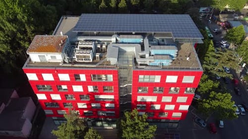 Red Modernist Building With A Solar Farm On The Roof