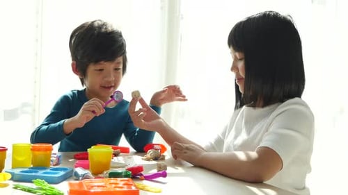 Child Sculpting Clay at Home with Friend