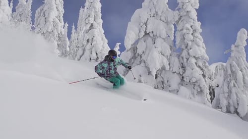 Ein Mann fährt im Winter einen schneebedeckten Berg hinunter.