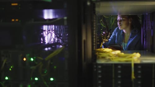 Woman Working with Servers and Tablet in Data Center