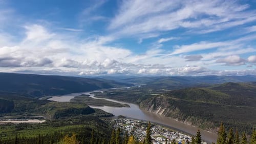 Time Lapse. Vista da cidade de Dawson de cima em um dia nublado e ensolarado