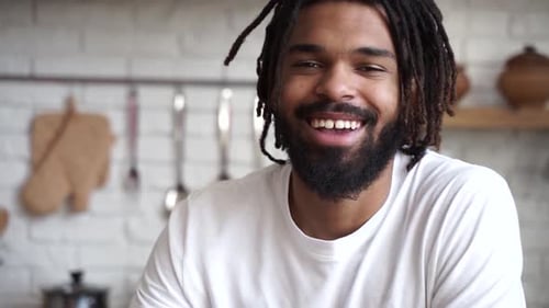 Smiling Man with Dreadlocks Drinks Coffee
