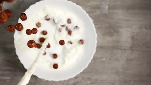 Chocolate Cereal and Milk Being Poured into Bowl