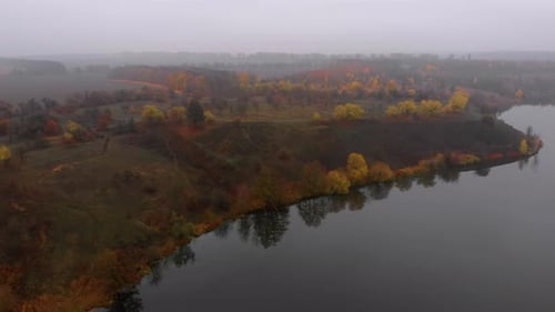 Aerial Drone Shot of Colorful Nature Near Big River in Fog at Late Autumn