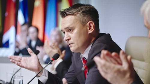 Man Speaks at International Conference, Audience Clapping