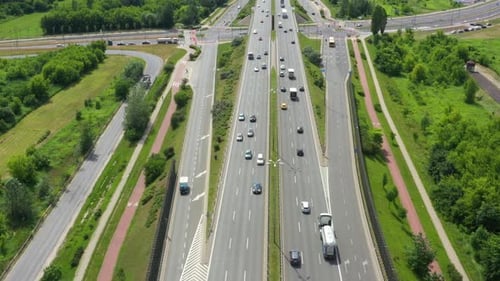 Blick von oben auf die Freay Road. Klipp. Autobahn mit Verkehr im Wald. Vorstadtautobahn mit Autos und Lastwagen.