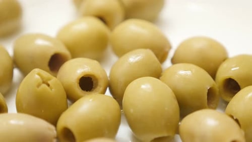 Ripe served green european table olives on the plate slow tilt 4K 2160p 30fps UltraHD video - Oleae