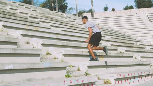 Black athlete running up steps