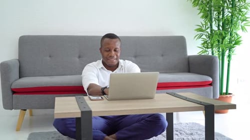 Young Adult Works on Laptop at Home