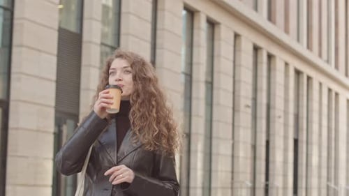 Portrait of Young Woman Drinking Takeaway Coffee in City Centre