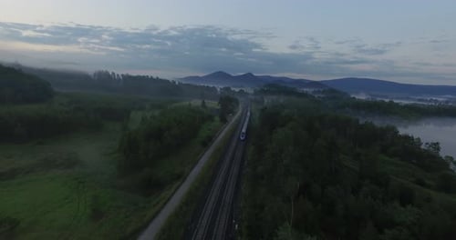 Train Traveling Through Scenic Landscape at Sunrise
