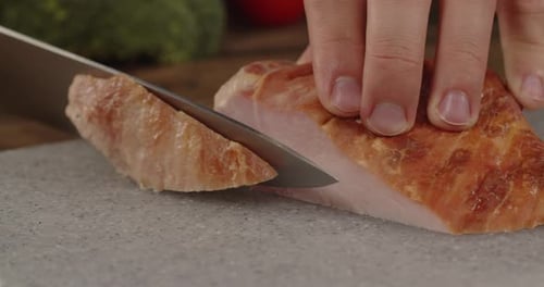Hands Cutting Slice of Meat With Knife