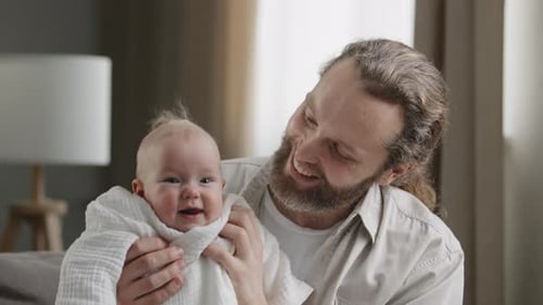 Happy Father Holding His Baby Indoors