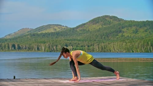Woman Practices Yoga on Dock by Lake