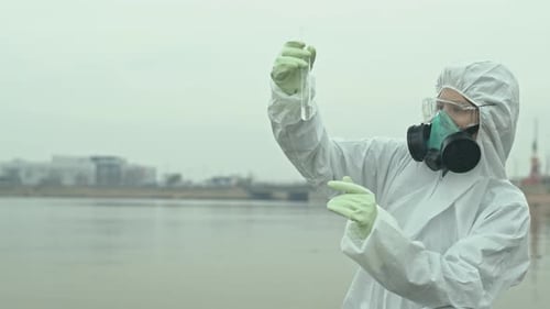 Scientist in Hazmat Suit Analyzing Water Sample