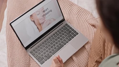 Woman Browsing Retail Website on Laptop at Home
