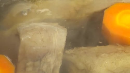 Simmering Beef Broth with Carrots Close Up