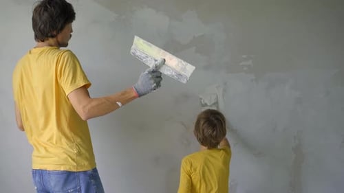 Man and Child Plastering a Wall Together