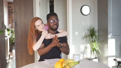 Young Couple Talking and Embracing at Home