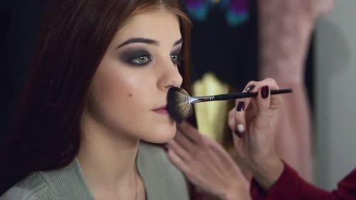 Makeup Artist Applying Face Powder on the Model's Face Using Special Brush