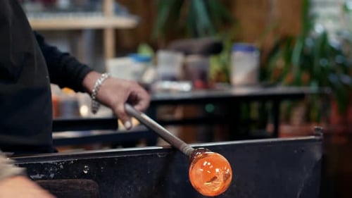 Glass Blower Forming Molten Glass in Workshop
