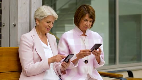 Happy Senior Women with Smartphones in City