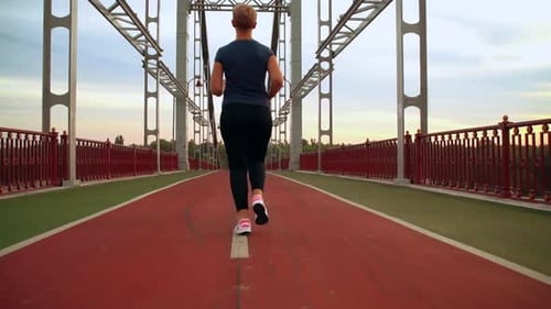 Girl Jogging on the Bridge in Urban City